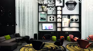 En moderne lounge med eklektisk indretning. Der er et opholdsområde med sorte og orange stole omkring cirkulære tæpper. En væg har hylder med kunst, en cykel og en stor læberillustration. Blød belysning og en sektionssofa fuldender rammerne.