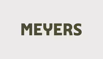 Billedet viser ordet "MEYERS" med fede, mørkegrønne store bogstaver centreret på en lysegrå baggrund.